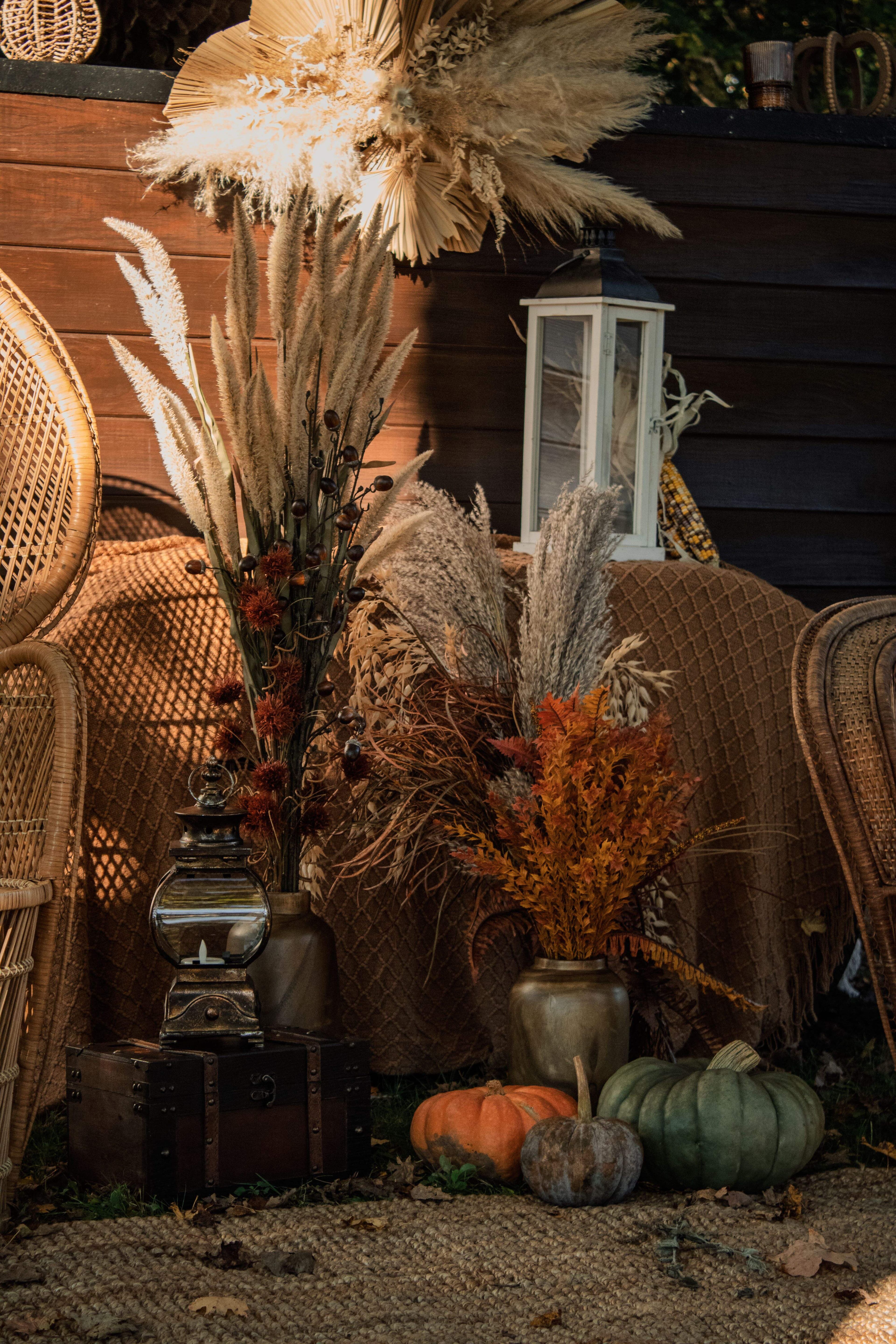 Styled still life of dried florals, lantern, and pumpkins